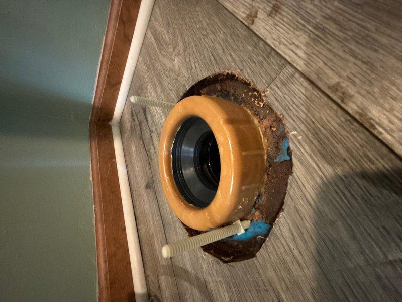 Responded to a toilet leak in an upstairs bedroom bathroom above the garage. Upon inspection, found the toilet had been leaking at the base, with visible rust staining and corrosion on the subfloor around the flange indicating prolonged moisture exposure. Removed the toilet and assessed the existing wax ring seal, which had failed and required replacement. The toilet flange was intact with mounting bolts in serviceable condition. Cleaned the flange area, removing old wax residue and debris from the previous seal. Installed a new wax ring seal and properly reset the toilet to the flange, ensuring a watertight connection. Secured the fixture with existing mounting hardware and tested for leaks. Toilet is now functioning properly with no active leaks detected.