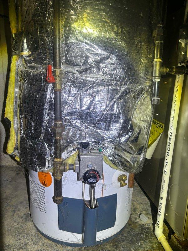 Responded to emergency service call for leaking 10+ year old 50-gallon gas water heater in basement utility room. Upon inspection, confirmed active leak originating from bottom of tank, indicating internal tank failure requiring immediate replacement. Assessed existing installation including gas supply line with shutoff valve, copper water supply piping, temperature/pressure relief valve, and venting configuration adjacent to furnace system. Documented current equipment condition and surrounding mechanical room layout. Provided estimate for replacement with new 50-gallon gas water heater to be installed within 24-48 hours to restore hot water service.