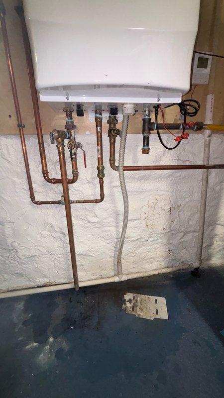 Diagnosed Navien 240A tankless water heater with condensation syphon failure. Sold repair estimate for condensation syphon replacement part, which is currently being ordered and is available at the shop. Unit inspection revealed corroded brass fittings and oxidation on water inlet connections, documented system condition with photographs for repair completion upon part arrival.