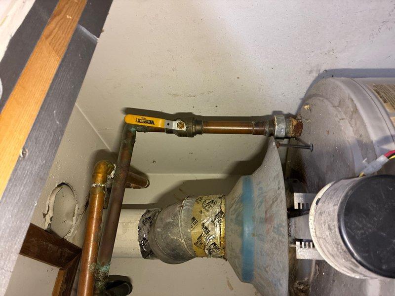 Responded to a no-ignition issue on a 100-gallon A.O. Smith tanked water heater located on the third floor. Upon arrival, found the unit had been previously disconnected in 2018 and the ignition wire had been pulled. Inspected all plumbing connections, copper piping with brass fittings, and electrical components at the top of the unit. Assessed the condition of the water heater tank and surrounding utility space, documenting existing installation with copper supply and outlet lines. The unit showed signs of age with visible patina on piping and general wear on tank surfaces, consistent with its service history and disconnected status.