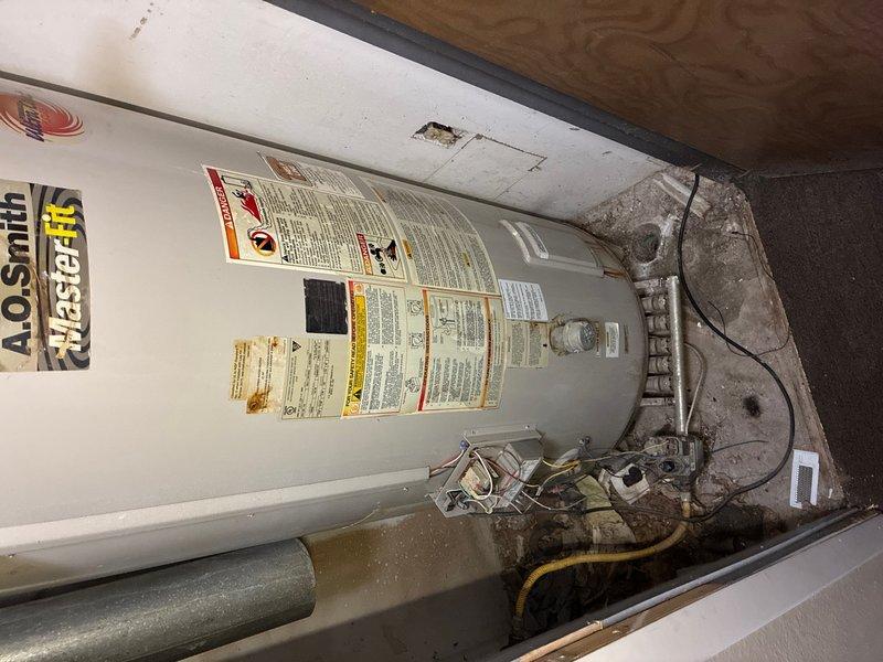Responded to a no-ignition issue on a 100-gallon A.O. Smith tanked water heater located on the third floor. Upon arrival, found the unit had been previously disconnected in 2018 and the ignition wire had been pulled. Inspected all plumbing connections, copper piping with brass fittings, and electrical components at the top of the unit. Assessed the condition of the water heater tank and surrounding utility space, documenting existing installation with copper supply and outlet lines. The unit showed signs of age with visible patina on piping and general wear on tank surfaces, consistent with its service history and disconnected status.