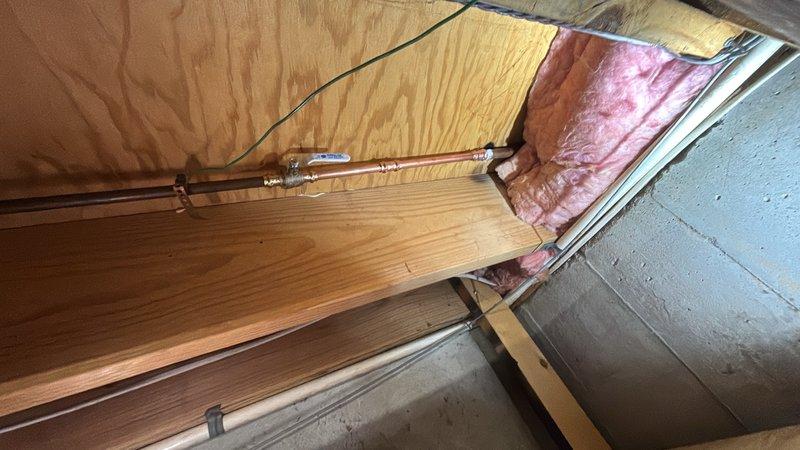 Replaced frost-free outside hose bib at exterior foundation location. Accessed interior plumbing connections through attic space, installed new copper supply line with proper insulation, and completed exterior mounting at foundation level near landscaped area. System tested and verified leak-free operation.