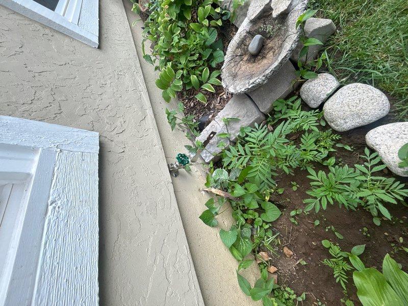 Replaced frost-free outside hose bib at exterior foundation location. Accessed interior plumbing connections through attic space, installed new copper supply line with proper insulation, and completed exterior mounting at foundation level near landscaped area. System tested and verified leak-free operation.