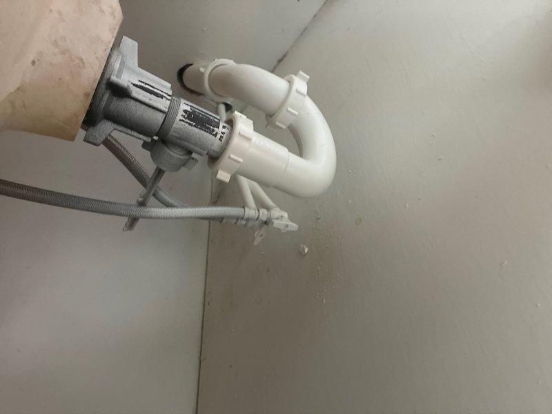 Provided comprehensive plumbing estimate for property requiring new water heater installation, first-floor toilet replacement, second-floor toilet reset, and first-floor vanity installation. Property currently has no existing water heater system. Assessed bathroom conditions showing ongoing renovation work with exposed wall access panels, existing bathtub with plumbing fixtures, and under-sink drainage assembly with PVC trap configuration. Documented all areas requiring plumbing installations and modifications to support new fixture placements.