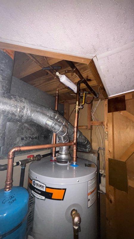 Completed installation of a 40-gallon STATE brand gas water heater in residential utility space with all necessary connections and safety components. Installed thermal expansion tank with proper copper piping connections, configured gas supply line using flexible yellow gas connector, and established hot and cold water distribution lines with brass shut-off valves. All plumbing connections were secured to manufacturer specifications, system was pressure tested for leaks, and unit was successfully commissioned and verified operational.