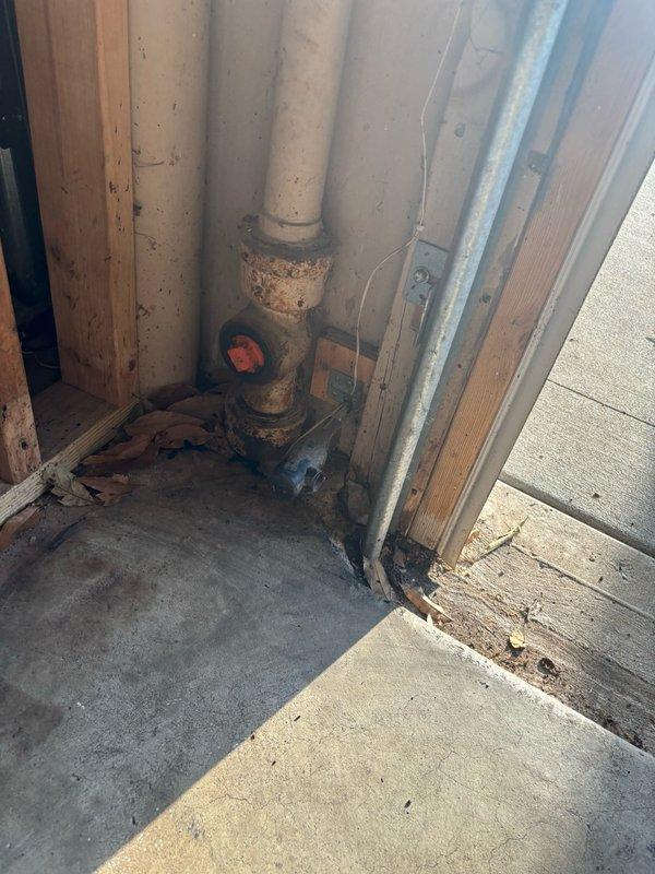 Responded to a backed up floor drain in the garage. Upon arrival, found significant standing water in a recessed pit area containing HVAC equipment, with water levels high enough to submerge most of the unit. Assessed the drainage system which included aging plumbing infrastructure with corroded valve assemblies and deteriorated piping. Cleared the clogged floor drain to restore proper drainage function and prevent further water accumulation around the mechanical equipment. The blockage was successfully removed, allowing standing water to drain and restoring normal floor drain operation.