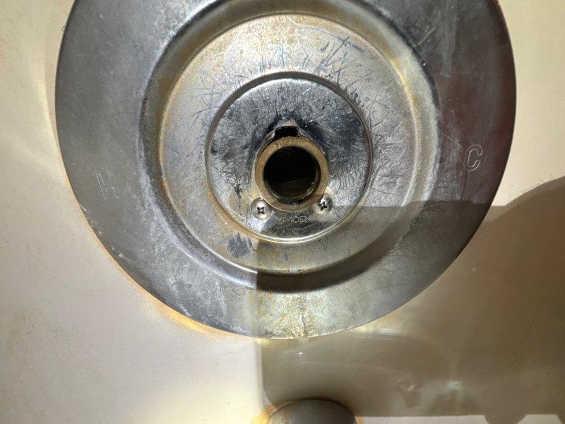 Responded to service call for dripping faucet underneath shower/tub fixture. Upon inspection, identified failed valve cartridge or stem assembly causing leak at base of faucet. Removed defective brass valve component and replaced with new fitting. Verified proper installation, tested water flow, and confirmed leak was eliminated. Unit restored to full working condition.