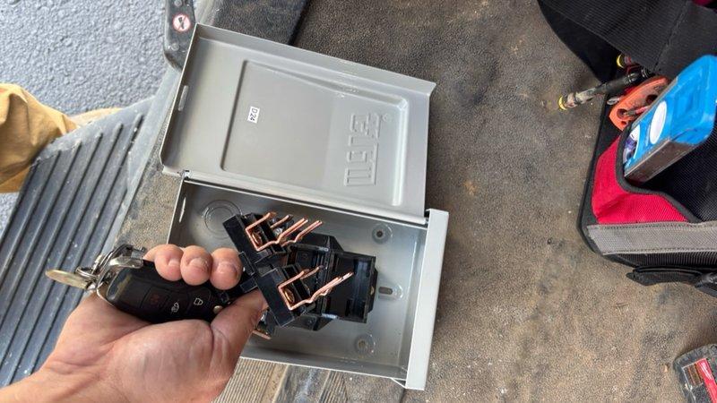 Replaced electrical disconnect box on commercial HVAC unit. Removed existing ETI disconnect enclosure and installed new gray metal disconnect box with proper electrical contactor and terminal connections. Verified all wiring connections were secure and properly terminated at relay device. Tested unit operation to confirm successful installation.