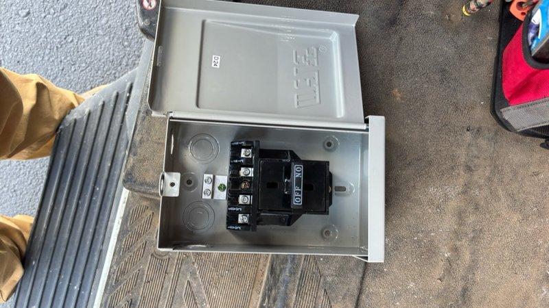 Replaced electrical disconnect box on commercial HVAC unit. Removed existing ETI disconnect enclosure and installed new gray metal disconnect box with proper electrical contactor and terminal connections. Verified all wiring connections were secure and properly terminated at relay device. Tested unit operation to confirm successful installation.