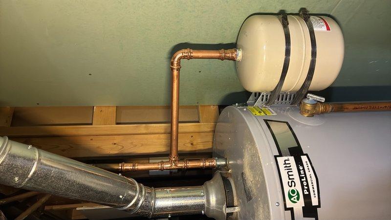 Replaced failed dip tube in tanked water heater and repiped the cold water supply line. Installed expansion tank and mounted it securely to the water heater tank with proper strapping, utilizing copper piping with brass fittings throughout the cold side connections to ensure proper system operation and thermal expansion protection.