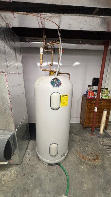 Installed new Essency electric water heater in basement utility area with proper copper piping connections and pressure relief valve. Repaired water leak located above the water heater and installed new 1/4 turn stop valve for humidifier line. Pulled and reset toilet to replace worn wax ring and stool bolts, inspecting and repairing toilet flange as needed to ensure proper seal and prevent future leaks.