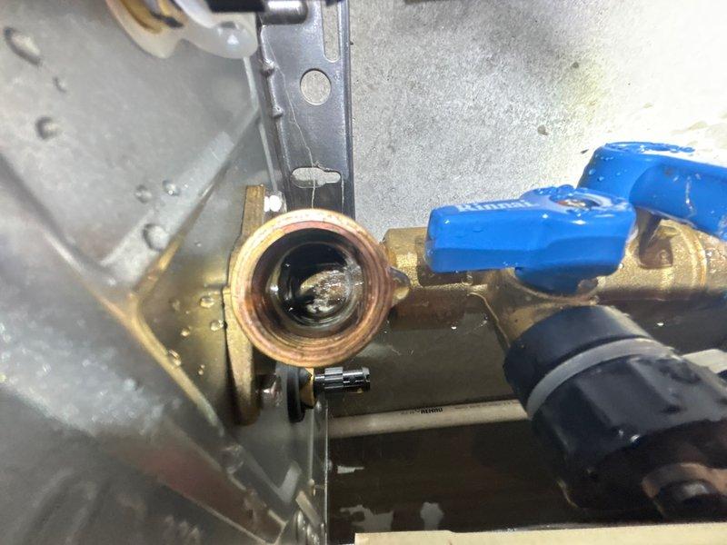 Responded to service call for leaking Rinnai tankless water heater. Upon inspection, identified active leak at brass valve assembly and pipe connections. Photographed affected components including blue-handled ball valves, brass fittings showing corrosion and mineral buildup, and associated piping. Documented condition of valve internals, threading, and mounting hardware. Provided estimate for necessary repairs to address leak source and restore system integrity.