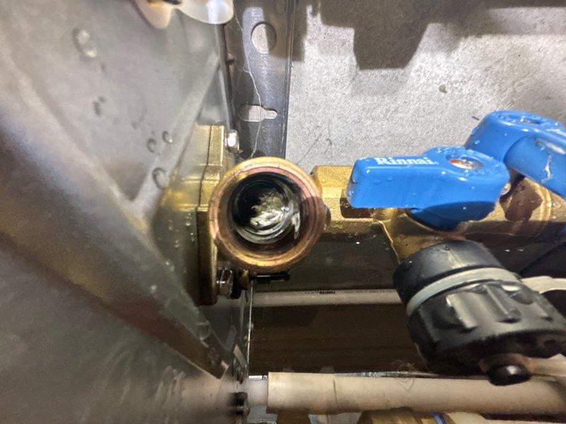 Responded to service call for leaking Rinnai tankless water heater. Upon inspection, identified active leak at brass valve assembly and pipe connections. Photographed affected components including blue-handled ball valves, brass fittings showing corrosion and mineral buildup, and associated piping. Documented condition of valve internals, threading, and mounting hardware. Provided estimate for necessary repairs to address leak source and restore system integrity.
