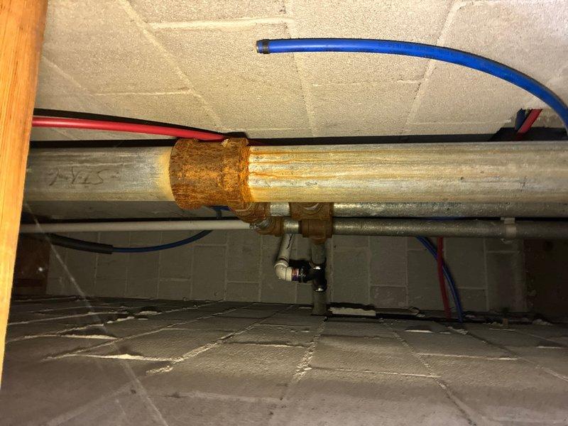 Conducted plumbing estimate for underground piping system replacement due to collapsed pipe. Inspection revealed extensive rust and corrosion on existing metal piping infrastructure located in crawl space, with significant oxidation present on horizontal pipe sections and connection fittings. Documented conditions of deteriorated piping system, including corroded metal flanges and couplings, to provide accurate assessment for complete pipe replacement and system restoration.