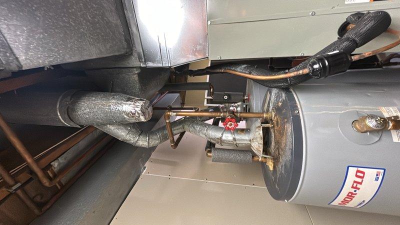 Installed 3/4" tech line with two SharkBite fittings on A.O. Smith water heater, creating a recirculation loop configuration. Drained and flushed sediment from the existing water heater tank to maintain efficiency and longevity. All copper piping connections with brass fittings and black foam insulation were properly secured, and the system was tested for proper operation with no leaks detected.