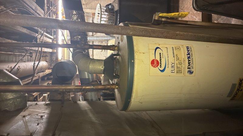 Responded to service call for 30-year-old water heater that leaked onto floor and extinguished pilot light, rendering unit inoperable. Assessed existing Rheem tank-style water heater located in basement and documented current installation configuration including supply lines, venting, and electrical connections. Provided estimate options for replacement including tankless water heater systems and traditional tank-style units to meet customer's needs.