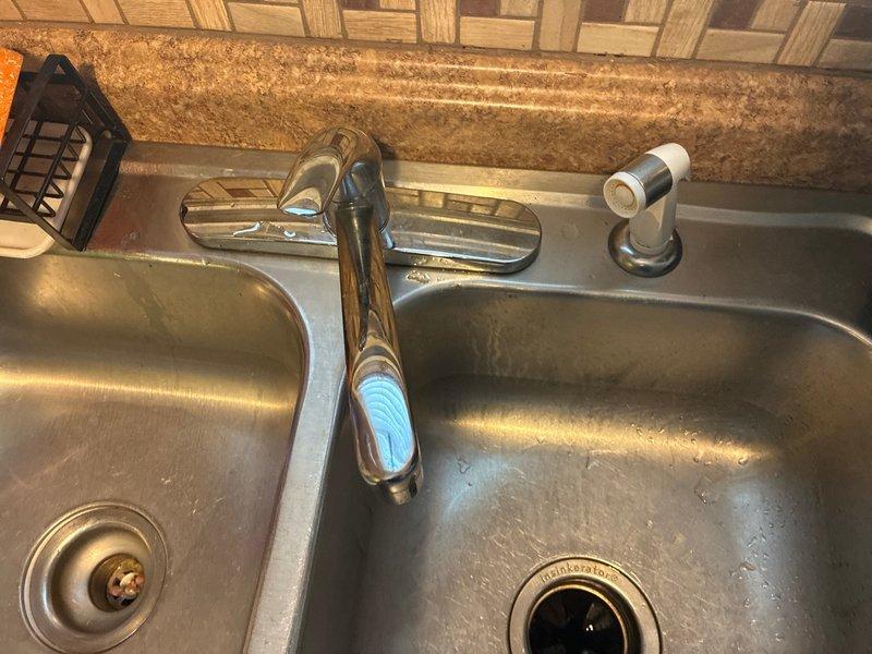 Completed on-site assessment for kitchen faucet replacement estimate. Evaluated existing single-handle pull-down faucet with chrome finish installed on stainless steel double-basin sink with decorative tile backsplash. Documented current plumbing configuration including supply line connections, shut-off valves, and mounting hardware to provide accurate replacement pricing and scope of work.