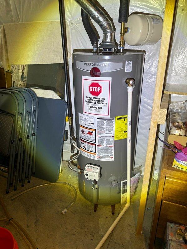Performed routine plumbing maintenance inspection of water heating system and under-sink plumbing. Inspected Performax Gel water heater installation in utility closet, verifying proper copper piping connections, expansion tank mounting, and safety label compliance. Examined under-sink cabinet plumbing, confirming PVC trap assembly and drain connections were functioning properly with no visible leaks or drainage issues.