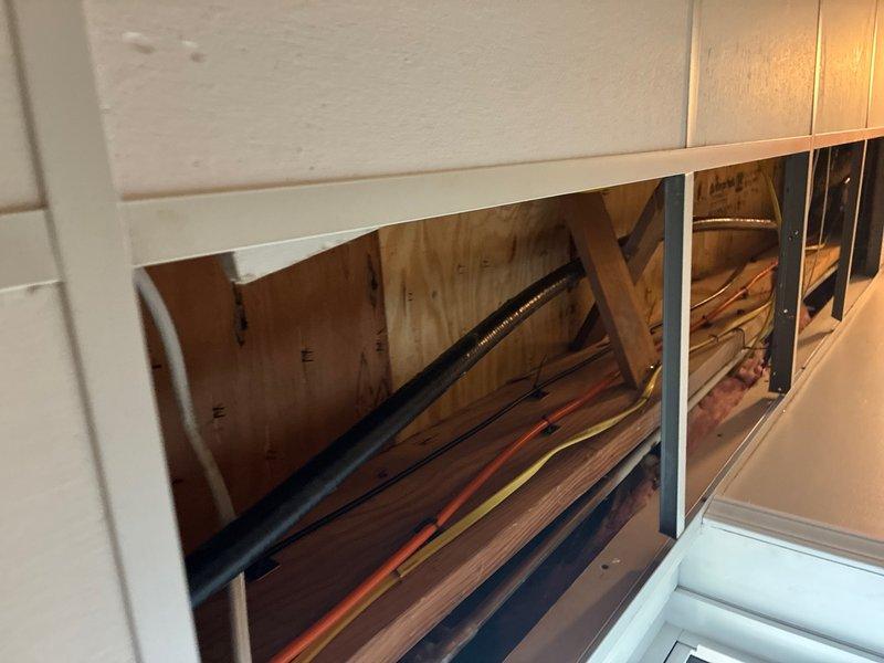Installed a new 1" gas line from existing basement supply to exterior generator location. Tied into accessible 1" gas line in basement with drop ceiling using a 1" tee fitting and shut-off valve, transitioned to flexible gas line for routing to back wall, then switched back to rigid pipe before penetrating exterior wall. Ran hard pipe along exterior deck perimeter to generator location, installed 90-degree fitting and reduced to 1/2" gas line with shut-off valve and drip leg at generator connection point. Performed pressure testing to verify system integrity and confirm no leaks present. Left gas supply valve in closed position pending generator commissioning.