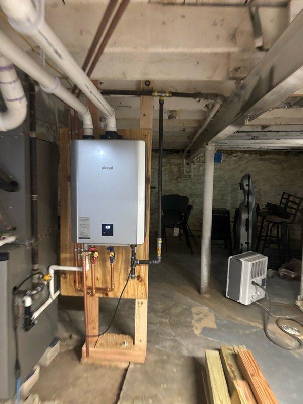 Responded to service call for Rinnai tankless water heater displaying error code 55 in basement. Diagnosed and resolved the issue, verified unit returned to proper operation with temperature control showing 120°F on digital display. Documented installation with photos showing copper piping connections, isolation valves, and proper mounting configuration.