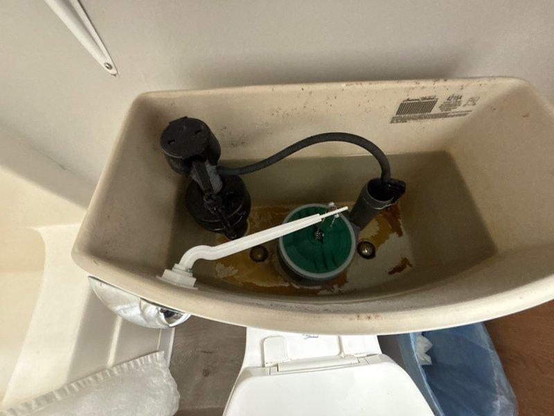 Responded to callback for two toilets not flushing properly following previous service. Inspected both bathroom toilet tanks and identified issues with flush mechanisms. Found discolored water and mineral deposits in tank indicating potential flapper valve deterioration affecting flush performance. Adjusted fill valve settings and tested flush operation on both toilets to restore proper flushing function.