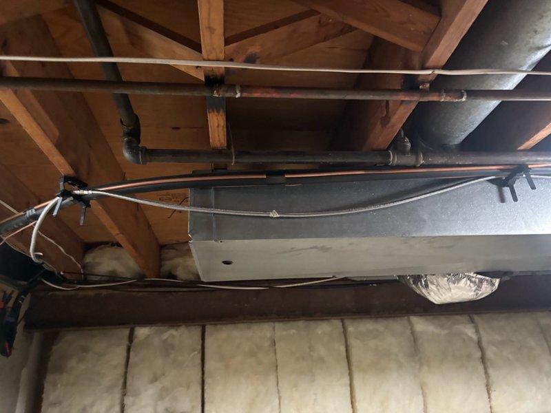 Installed ice maker supply line from appliance location to quarter turn shut-off valve in basement area. Routed copper piping through ceiling joists and secured with appropriate mounting brackets to wooden framing members. Connected braided stainless steel flex line from supply pipe to appliance connection point, ensuring proper fittings and leak-free connections throughout the installation.