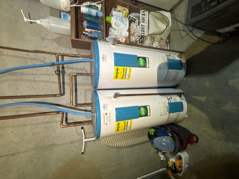 Conducted comprehensive assessment of dual 10-year-old electric water heaters in basement utility room to provide replacement estimate. Both units currently operational with standard copper piping and PEX distribution lines. Evaluated existing electrical connections, plumbing infrastructure including hot and cold water supply lines, pressure relief valve configurations, and drainage requirements for future replacement planning.