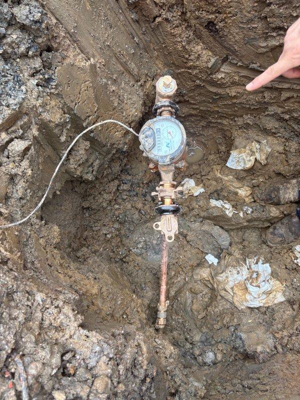 Responded to a water meter leak requiring immediate attention. Excavated around the existing meter pit to gain access to the compromised meter set kit. Removed the old meter pit and meter assembly from the saturated excavation site. Installed a new meter set kit with proper copper fittings and connections, reinstalled the water meter, and set a new meter pit with lead seal. Upon initial assessment, emptied standing water from the old pit which refilled, confirming an active leak at the meter location. Completed backfill and compaction around the new meter pit installation. Advised that additional repairs may be necessary if future leaks develop downstream of the meter assembly.