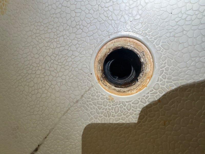 Responded to reported water leak from shower into garage. Upon inspection, identified failed shower drain gasket as the source of the leak. The drain assembly exhibited significant deterioration, with visible corrosion, rust buildup, and mineral deposits around the drain fixture. Removed the corroded drain ring, which showed extensive oxidation and moisture damage throughout. Replaced the failed gasket and drain components to restore proper seal and prevent further water intrusion into the garage below.
