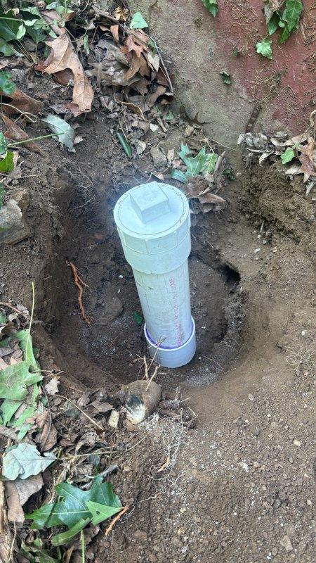 Performed underground PVC pipe repair by hand excavating to expose the damaged section buried in soil adjacent to exterior structure. Removed and replaced the compromised pipe section with new PVC material, then installed a 3-inch cleanout cap for future maintenance access. Backfilled the excavated area with soil upon completion of the installation.