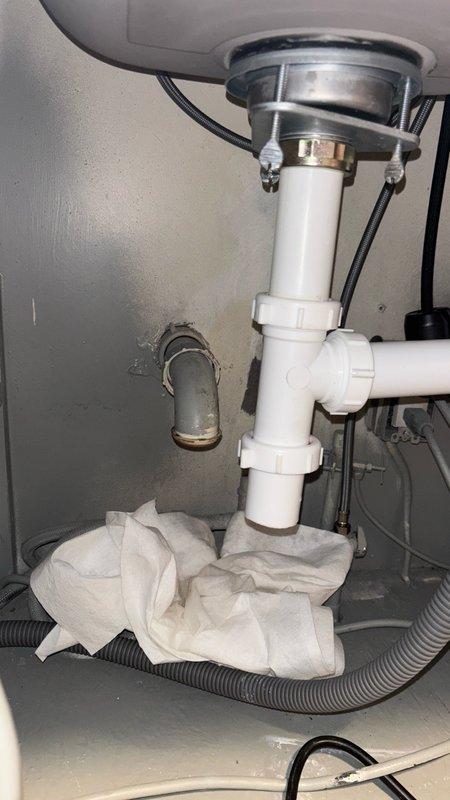 Responded to emergency main drain cleanout service for newly purchased residence experiencing severe kitchen drainage issues preventing sink usage. Upon inspection, identified blockage in main drain line affecting kitchen sink plumbing system with double-bowl stainless steel undermount configuration. Successfully cleared main drain obstruction using professional drain cleaning equipment, restoring full drainage capability to kitchen sink and disposal system. Verified proper water flow through both basin drains and tested all connections under sink cabinet for leaks. Inspected PVC drain assembly and fittings beneath sink to ensure structural integrity post-cleanout. All drainage systems returned to normal operation with no leaks detected.