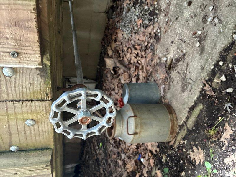 Responded to reported water leak at residential property. Upon inspection, identified severely corroded outdoor hose bib with visible rust staining and oxidation around the spout and valve body. The brass fixture showed significant deterioration due to extended weather exposure. Additionally, inspected crawl space plumbing connections and discovered corroded pipe fittings with brownish-red oxidation on metal joints, indicating advanced deterioration of the piping system. Documented all affected areas with photographs showing the extent of corrosion on both the exterior hose bib and interior pipe connections. Provided estimate for replacement of corroded fixtures and repair of deteriorated piping components to prevent further water damage and restore proper function to the plumbing system.