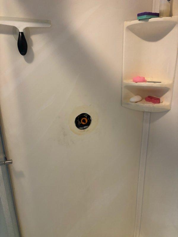 Responded to service call for shower cartridge replacement in primary bedroom bathroom. Accessed shower valve assembly through wall opening, removed existing cartridge from brass mounting plate, and installed new replacement cartridge. Verified proper operation of shower controls and water flow upon completion.