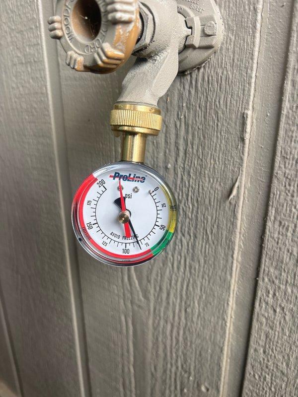 Performed comprehensive evaluation of 40-gallon Hotpoint water heater approximately 20 years old showing signs of rust deterioration and active minor leak. Assessed water pressure at exterior hose bib using calibrated gauge, inspected copper supply line connections and brass fittings at unit top, and documented current system condition. Provided detailed estimate for complete water heater replacement due to age-related component failure and ongoing leak issue.