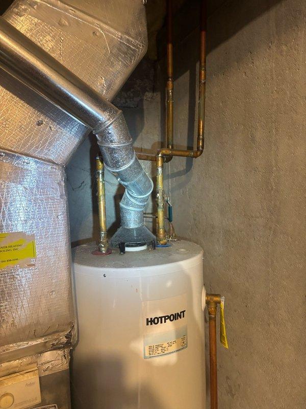 Performed comprehensive evaluation of 40-gallon Hotpoint water heater approximately 20 years old showing signs of rust deterioration and active minor leak. Assessed water pressure at exterior hose bib using calibrated gauge, inspected copper supply line connections and brass fittings at unit top, and documented current system condition. Provided detailed estimate for complete water heater replacement due to age-related component failure and ongoing leak issue.