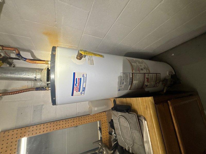 Responded to commercial property for non-functioning water heater replacement estimate. Assessed existing 40-gallon unit located in restroom facility, confirmed unit age exceeded 34 years and was inoperative. Documented existing installation including water supply connections, gas line configuration, and venting system. Photographed site conditions showing water-stained ceiling panels above unit indicating potential previous overflow or condensation issues. Provided estimate for replacement with new 40-gallon capacity commercial water heater to restore hot water service to facility.