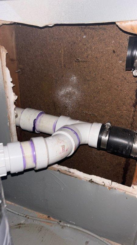 Accessed the kitchen sink drain/vent line by cutting the backside of the cabinet. Removed the existing corroded drain line and augered the blockage to restore proper drainage flow. Once line was cleared and drainage confirmed, installed new PVC drain piping underneath the kitchen cabinet with proper connections and purple-primed joints. Completed installation with insulation and performed final testing to verify proper drainage and leak-free operation.