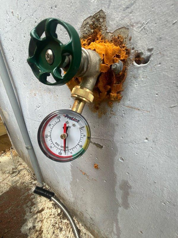 Completed comprehensive whole-home plumbing inspection as requested. Evaluated all accessible plumbing fixtures, supply lines, drain systems, and water pressure throughout the property. 

During the inspection, identified significant corrosion and rust deterioration on wall-mounted water valve assembly with pressure gauge. The brass pipe fitting where it enters the wall showed severe orange-brown rust with flaking material and compromised structural integrity. This corroded fitting presents potential leak risk and requires monitoring or replacement to prevent future water damage.

Inspected accessible areas including storage spaces with exposed plumbing infrastructure. Verified routing of supply lines and drainage systems through structural framing. All other visible plumbing components, fixtures, and connections appeared functional with no immediate concerns noted at time of inspection.