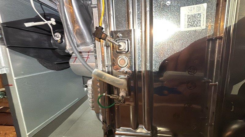 Responded to error code on 10-year-old tankless water heater unit in basement. Performed diagnostic inspection of unit components, including heat exchanger, electrode assembly, flame rod, and condensate drain system. Documented system condition with photographs showing internal components, ductwork connections, refrigerant lines, and component labeling for service records.