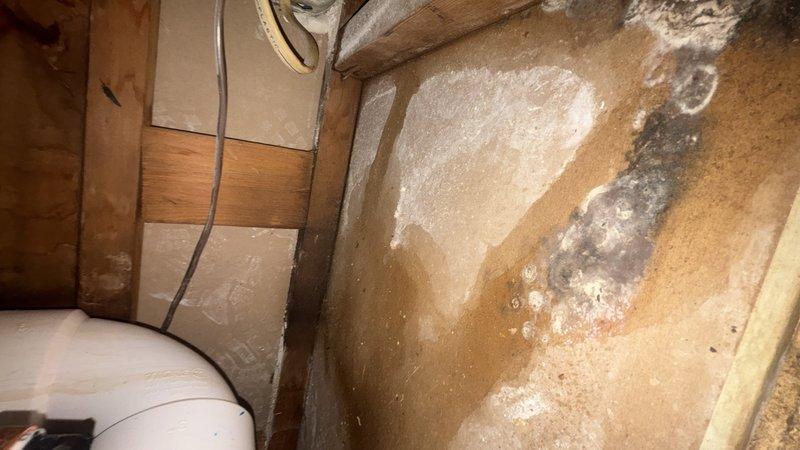 Responded to callback for toilet leak that persisted following previous repair attempt. Upon inspection, discovered significant water damage and moisture infiltration in crawlspace area beneath bathroom, with extensive mineral deposits, efflorescence, and evidence of ongoing leak penetrating subfloor. Documented deteriorated plywood subflooring with advanced water staining, mold growth, and structural concerns from prolonged moisture exposure. Traced leak source to failed wax ring seal at toilet flange connection that was not properly addressed during initial service visit. Removed toilet, replaced defective wax ring with reinforced seal, inspected and secured flange mounting, reinstalled fixture with proper torque specifications, and tested for leaks under multiple flush cycles to confirm repair integrity.