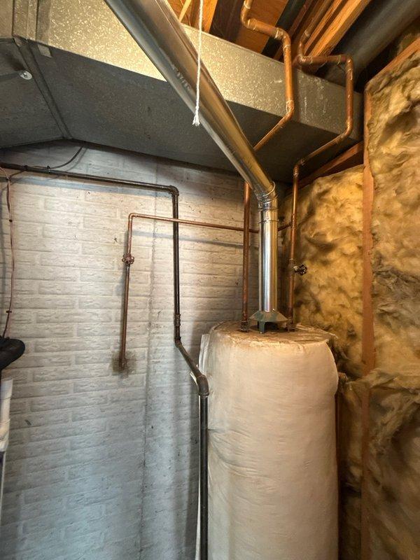 Completed installation of a 40-gallon gas water heater, model GS6 40 BCT 410, manufactured by State Industries, LLC, in residential basement utility area. Unit features 40,000 BTU input rating with 42-gallon recovery capacity and operates at 5" gas pressure, meeting CSA/ANSI Z21.10.1/CSA 4.1-2019 standards and National Appliance Energy Conservation Act requirements. Installed thermal expansion tank to protect plumbing system from excessive pressure buildup during water heating cycles. Connected copper supply and discharge piping to water heater with proper fittings and configurations. Integrated installation with existing plumbing infrastructure, including vertical and horizontal copper pipe runs throughout the mechanical space. Verified all connections for proper seal and operation. Installation completed in accordance with manufacturer specifications and applicable building codes.