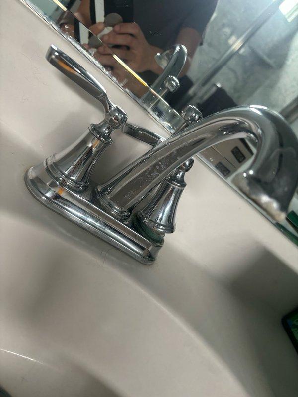 Replaced zinc faucet assembly in master bathroom with new chrome two-handle faucet featuring traditional cross-style handles and polished finish. Installed new braided stainless steel flexible water supply lines connected to hot and cold shut-off valves. Verified proper P-trap configuration and drain assembly connections, ensuring all fittings are secure and leak-free. Tested water flow and handle operation to confirm proper functionality of the new fixture.