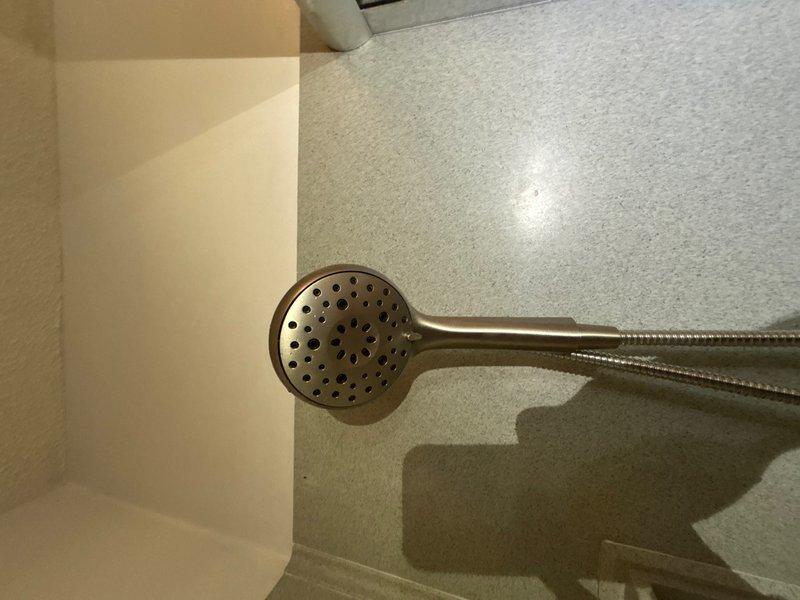 Completed installation of customer-supplied shower valve and handheld showerhead assembly with flexible braided metal hose in bronze finish. Installed customer-provided bathroom faucet with pop-up drain assembly on undermount sink, featuring brushed nickel finish with single-handle operation. Performed re-caulking of master bathroom shower enclosure to ensure proper water seal and prevent moisture intrusion.