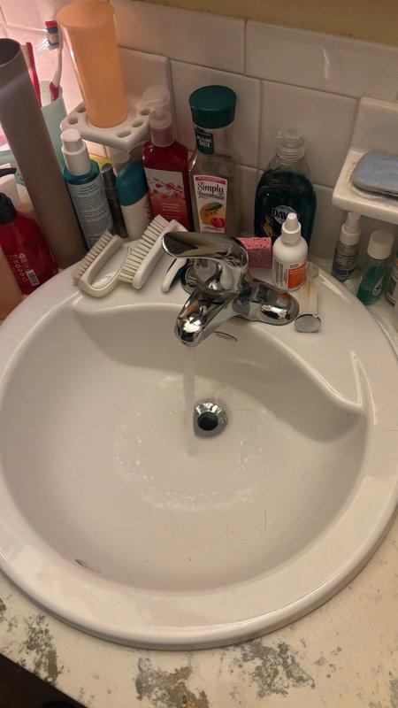 Responded to service call for clogged main floor bathroom sink with backup issue. Upon arrival, contacted customer 30 minutes prior as requested and arrived within scheduled window. Inspected white porcelain sink with chrome drain assembly and determined blockage in drain line causing water backup. Cleared obstruction using appropriate drain clearing methods, restoring proper drainage and flow. Tested sink operation to confirm issue resolved and drain functioning normally.