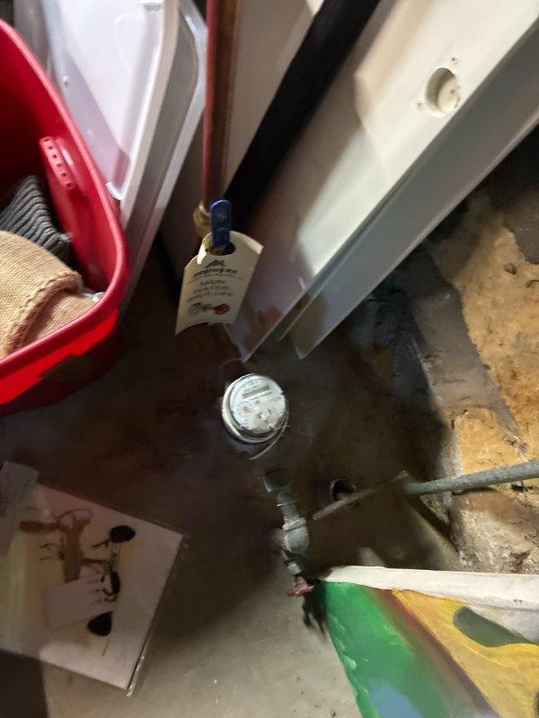 Performed preventive plumbing maintenance inspection of main water supply system. Tagged main water shut-off valve with identification label for easy emergency access. Inspected water meter, copper supply lines, and shut-off mechanisms for proper operation and potential leaks. Documented current condition of plumbing components and utility area with photographic records showing water meter readings, main shut-off location, and surrounding mechanical systems.