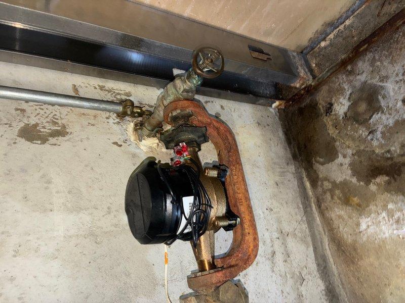 Responded to reported water leak from shut-off valve in basement. Upon inspection, identified active leak at corroded shut-off valve assembly connected to water meter. The existing valve exhibited severe corrosion and oxidation on copper piping and brass fittings, with visible rust patina and mineral deposits indicating prolonged moisture exposure. Shut off main water supply and replaced failed shut-off valve with new brass ball valve. Removed deteriorated section of copper pipe showing advanced corrosion and greenish oxidation buildup. Installed new copper pipe section using proper soldering techniques and secured all connections with appropriate brass compression fittings. Tested system for leaks by restoring water pressure and verified proper valve operation. Confirmed no active leaks at valve assembly or connections. Documented pre-existing conditions showing significant corrosion throughout plumbing assembly and water staining on concrete surfaces.
