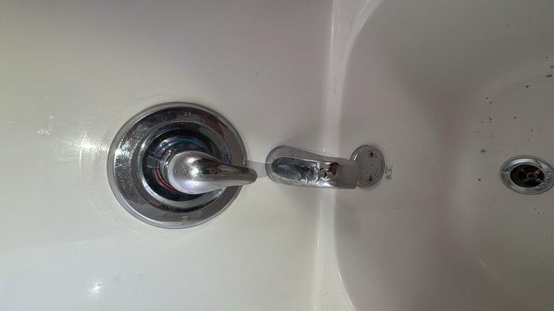 Installed customer-supplied shower valve assembly in bathtub enclosure. Completed all necessary plumbing connections using copper piping with soldered joints, integrated pressure regulator valve with gauge, and mounted chrome fixtures including single-handle control valve and tub spout with diverter. All components tested and operational upon completion.
