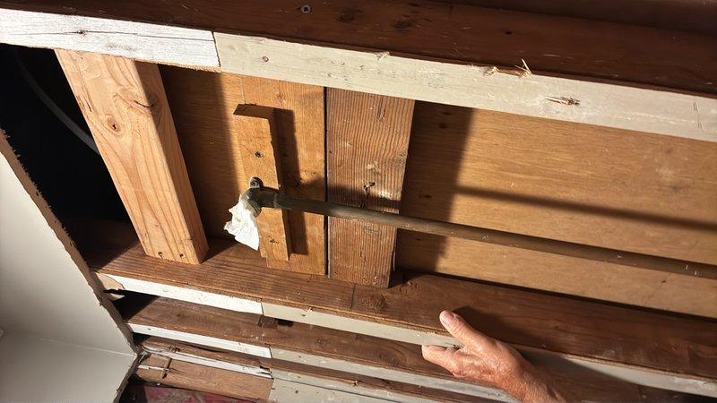 Completed plumbing estimate for pipe revision work requiring vertical adjustment of existing piping system. Assessed attic/crawlspace area to determine scope of work needed to lower pipes as specified, documenting current framing configuration and clearance constraints that will impact pipe routing modifications.