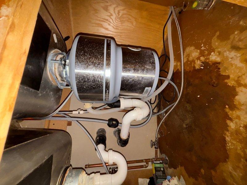 Responded to a kitchen faucet installation issue where the homeowner attempted a DIY replacement that resulted in a leak under the sink. Successfully completed the proper installation of a modern pull-down kitchen faucet with spray head attachment on a double-basin stainless steel sink, ensuring all connections were properly sealed and secured. Inspected and addressed the under-sink plumbing connections, verified the garbage disposal unit and drain assembly connections were leak-free, and tested the entire system to confirm proper water flow and drainage with no leaks present.