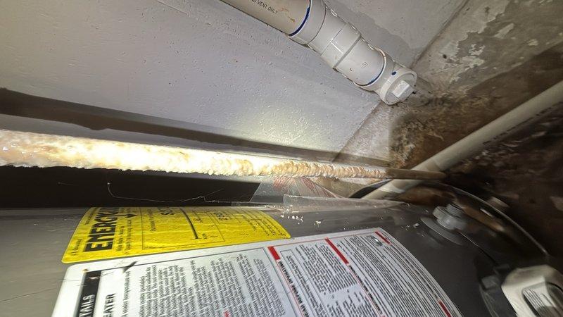 Responded to report of water heater leaking from the bottom in basement. Upon inspection, confirmed active leak at base of tanked water heater unit. Assessed unit condition and determined leak source from tank failure. Replaced failed water heater with new unit, ensuring proper connections to existing copper supply lines and galvanized piping assembly. Installed temperature and pressure relief valve, verified all connections for proper seal and function. Tested new water heater operation and confirmed no leaks present. Documented installation with photographs for service records.